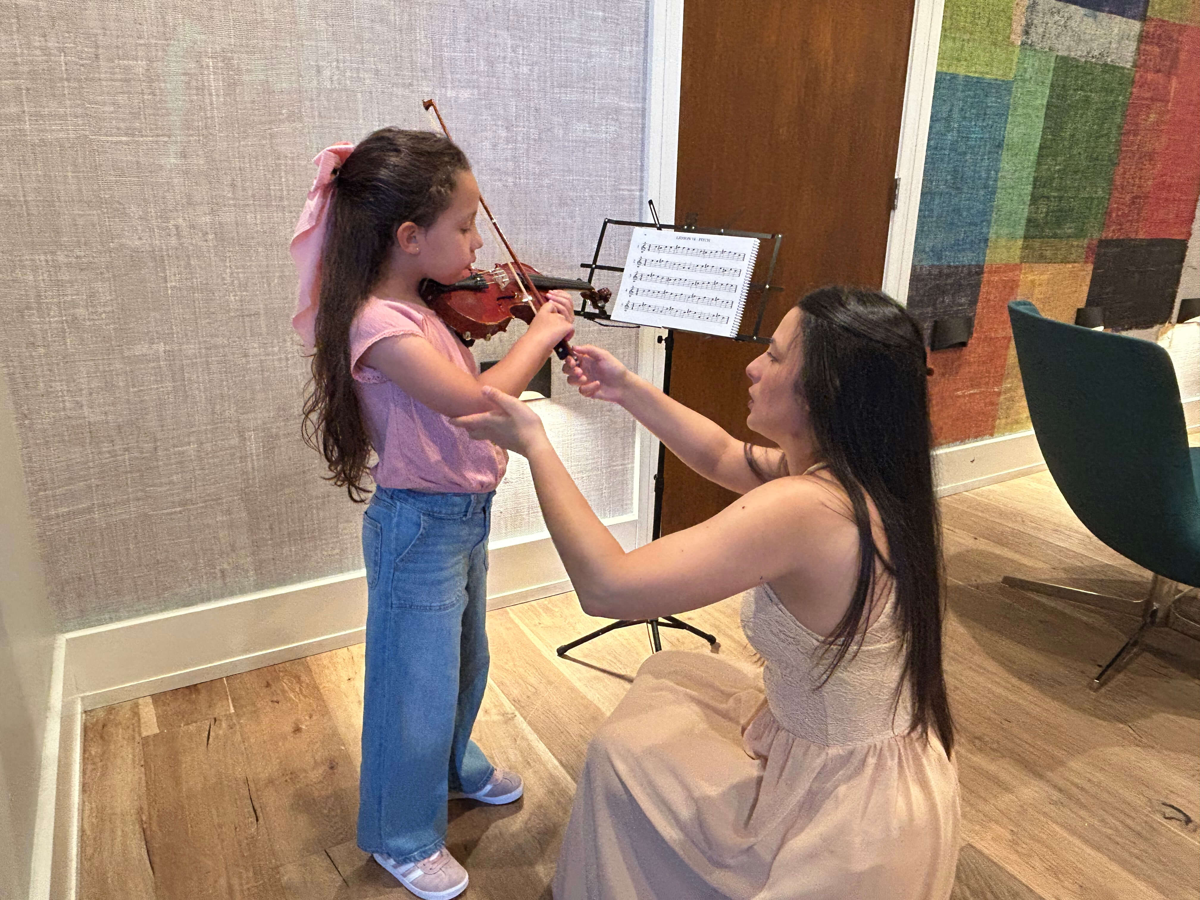 Ex Corde Academy student playing the violin with his teacher