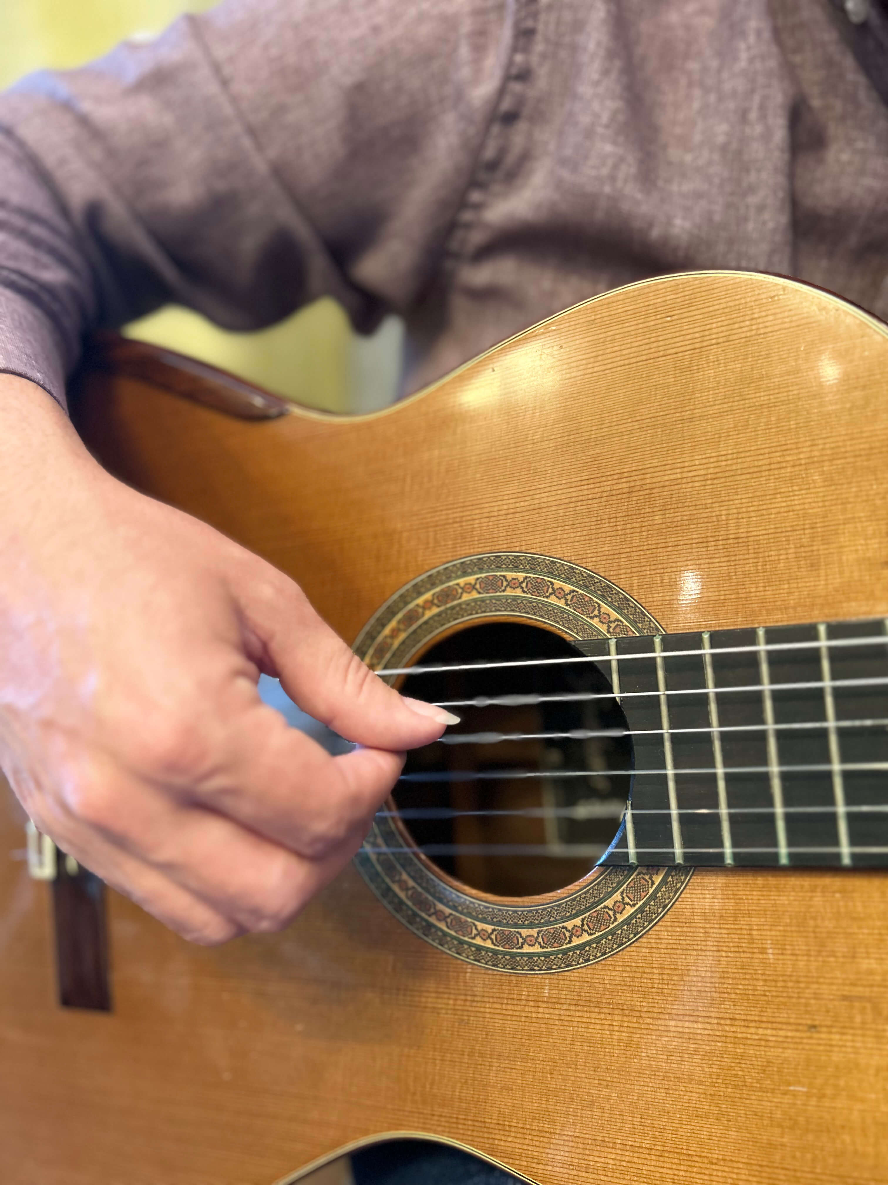 Photo of a guitar in the hands of the co-founder of the music academy